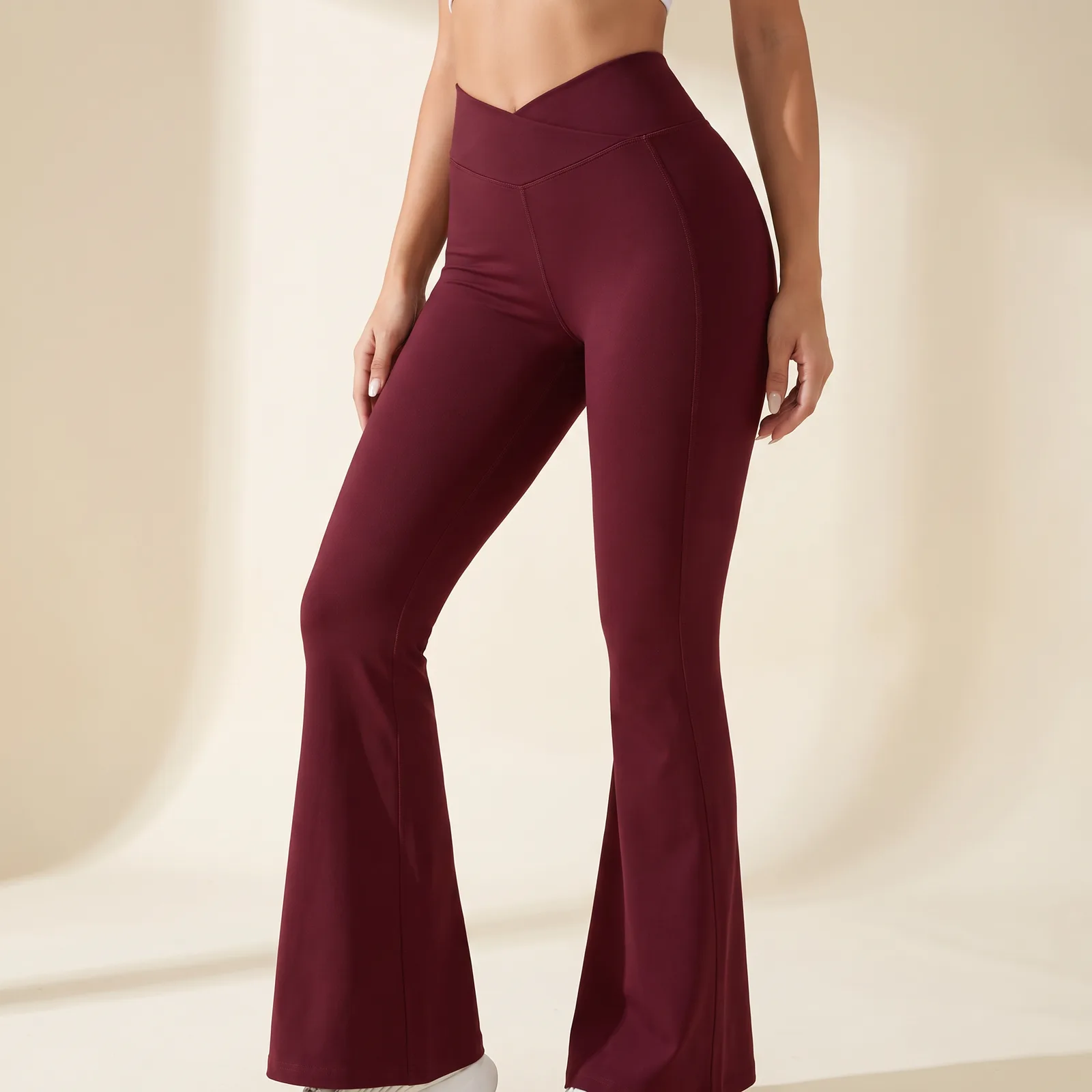 Crossover Flare Yoga Pants in Burgundy on a cream studio background