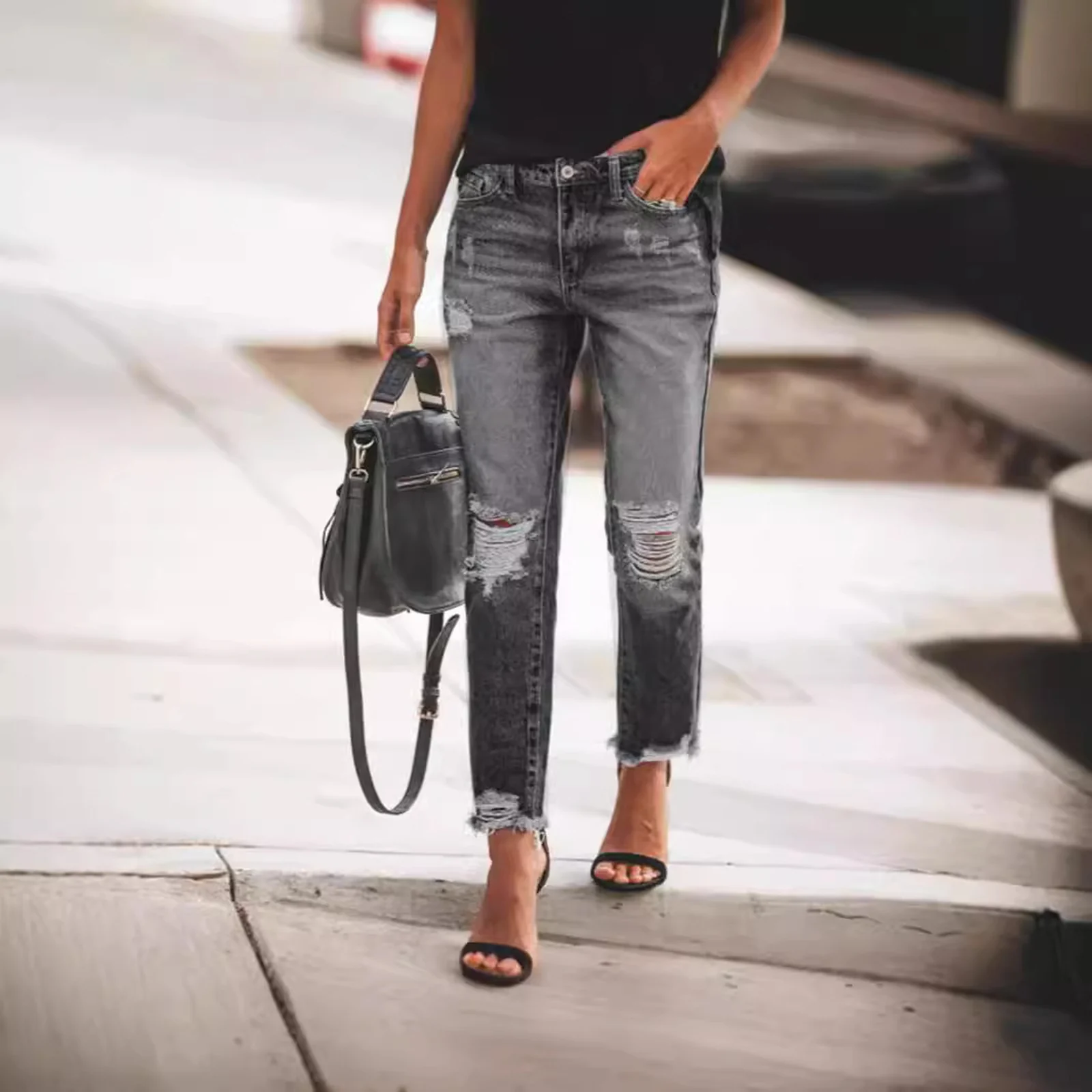 Distressed Straight-Leg Jeans in Light Wash worn with a black top, walking