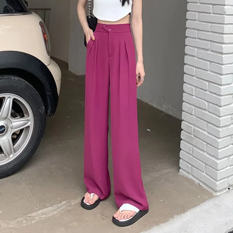 A person wearing magenta wide-leg trousers with a high-waisted fit and button detail