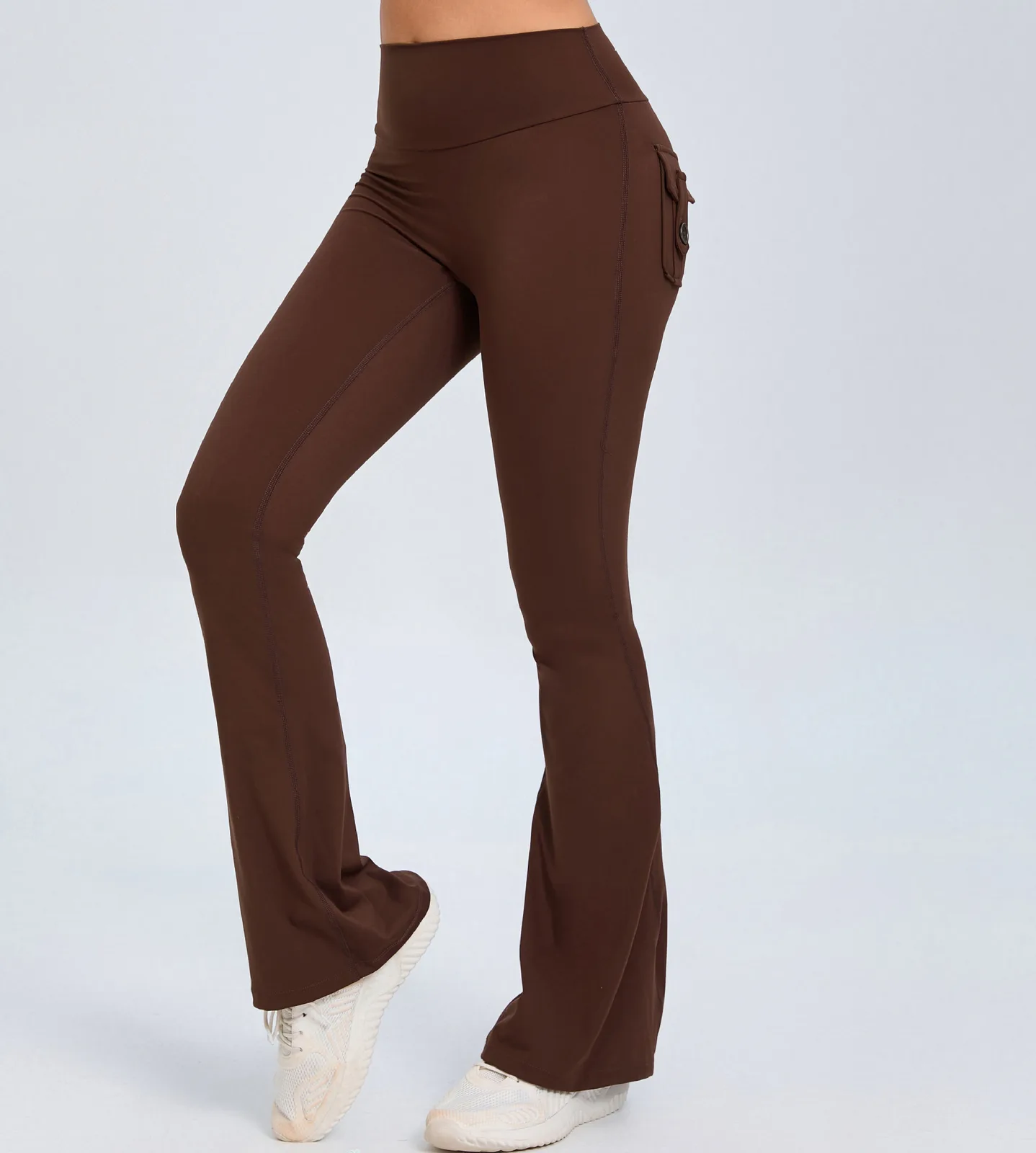 A person wearing brown flare leggings with a side pocket on a plain background