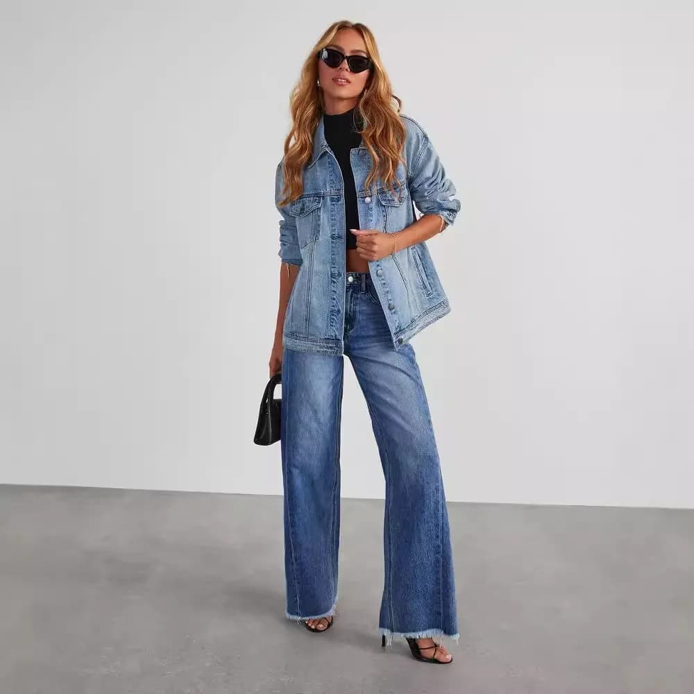 A woman wearing high-waist wide-leg jeans with a frayed hem and a denim jacket