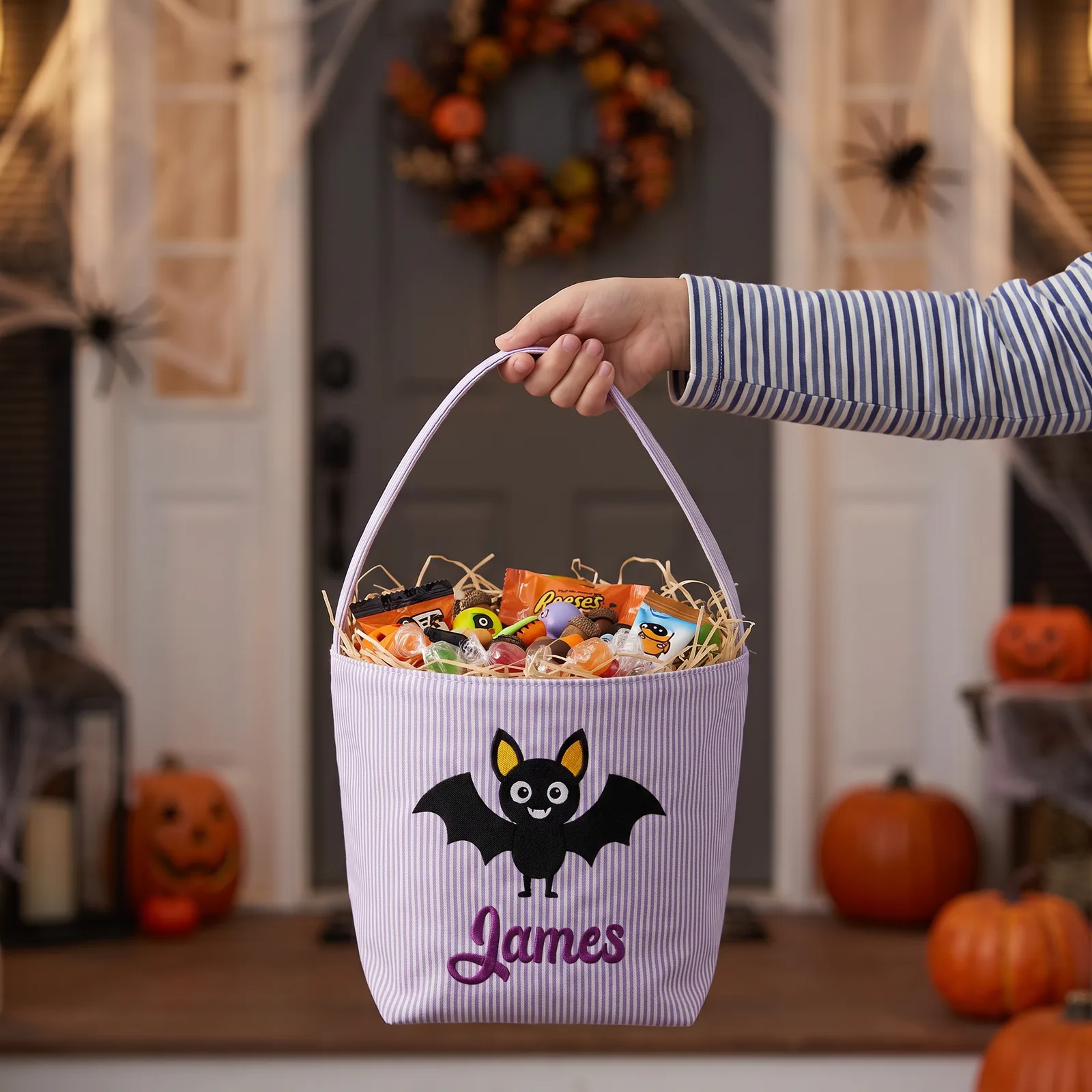 Child holding a purple personalized trick-or-treat basket