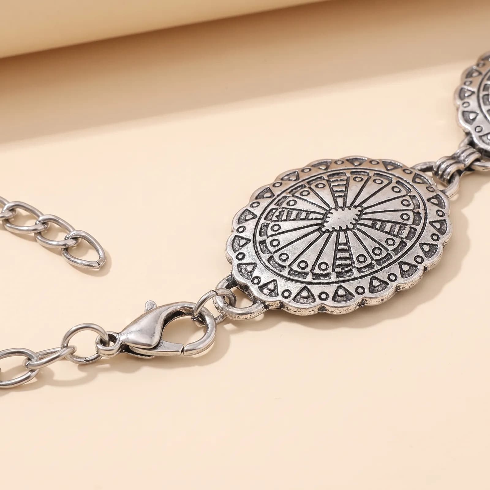 Close-up of an oval concho medallion and the lobster clasp