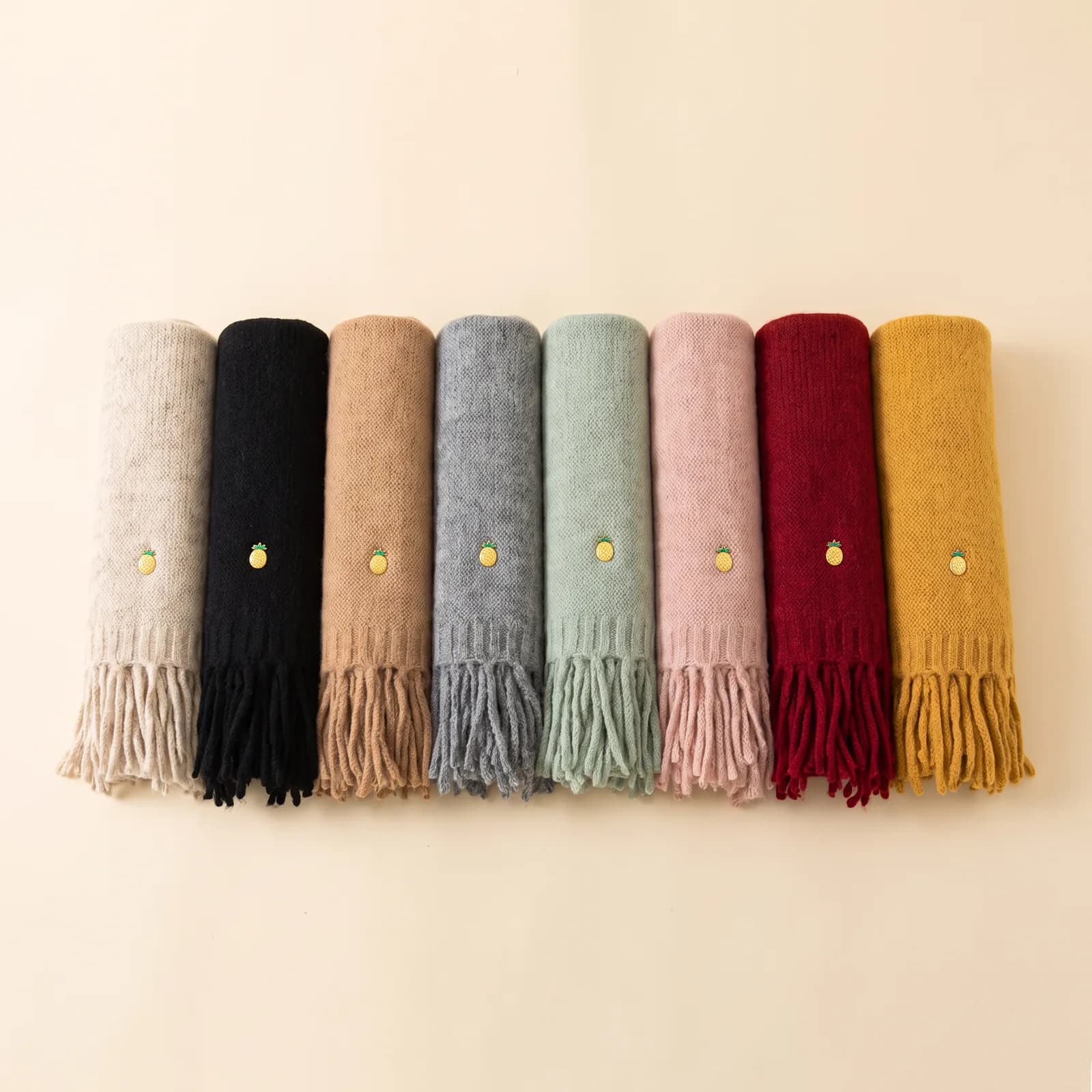 Oat, Black, Camel, Grey, Sage, Blush, Red, and Mustard scarves lined up side by side