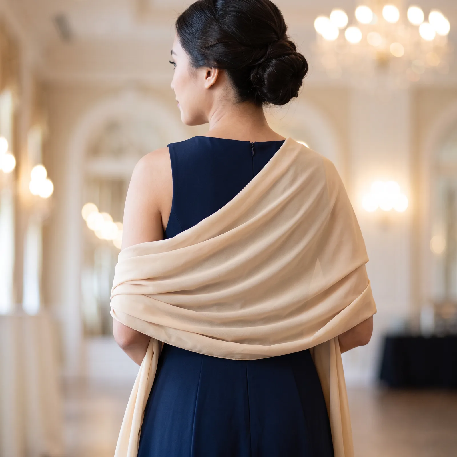 A sheer solid shawl draped over bare shoulders and an evening dress, no face