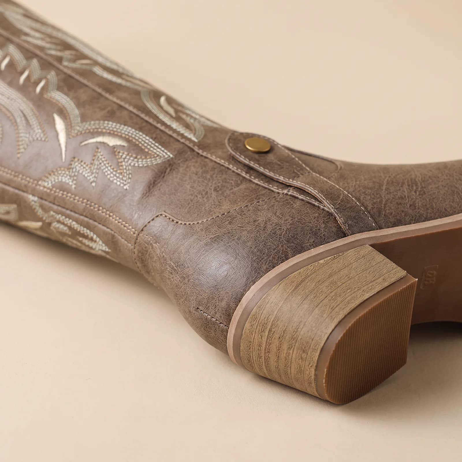Close-up of the chunky stacked heel and embroidered shaft
