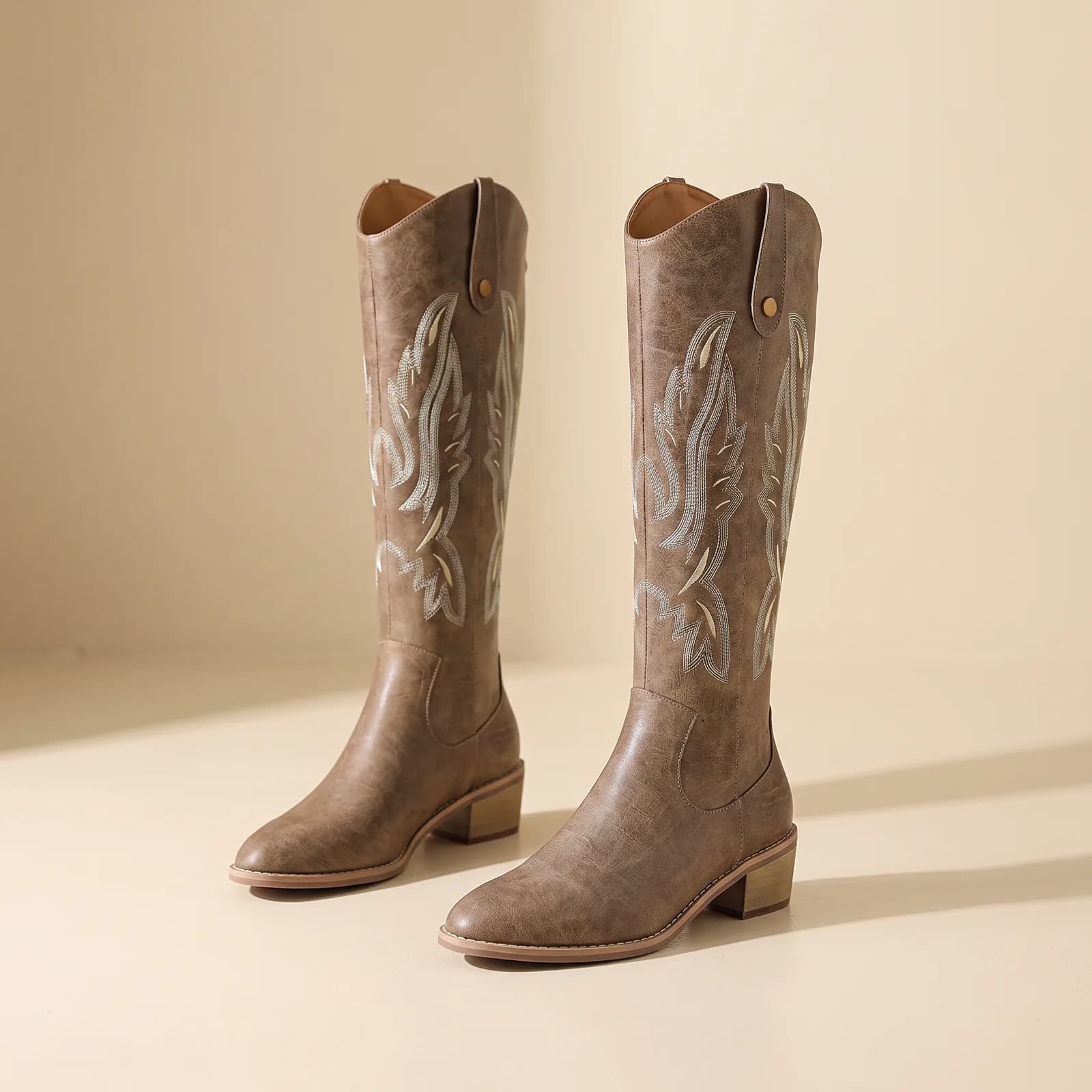 Chunky-Heel Western Boots in Cognac on a cream studio background