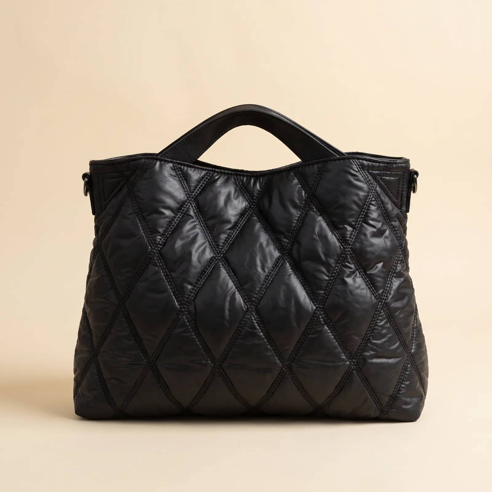 Down Puffer Commuter Tote in Black on a cream studio background