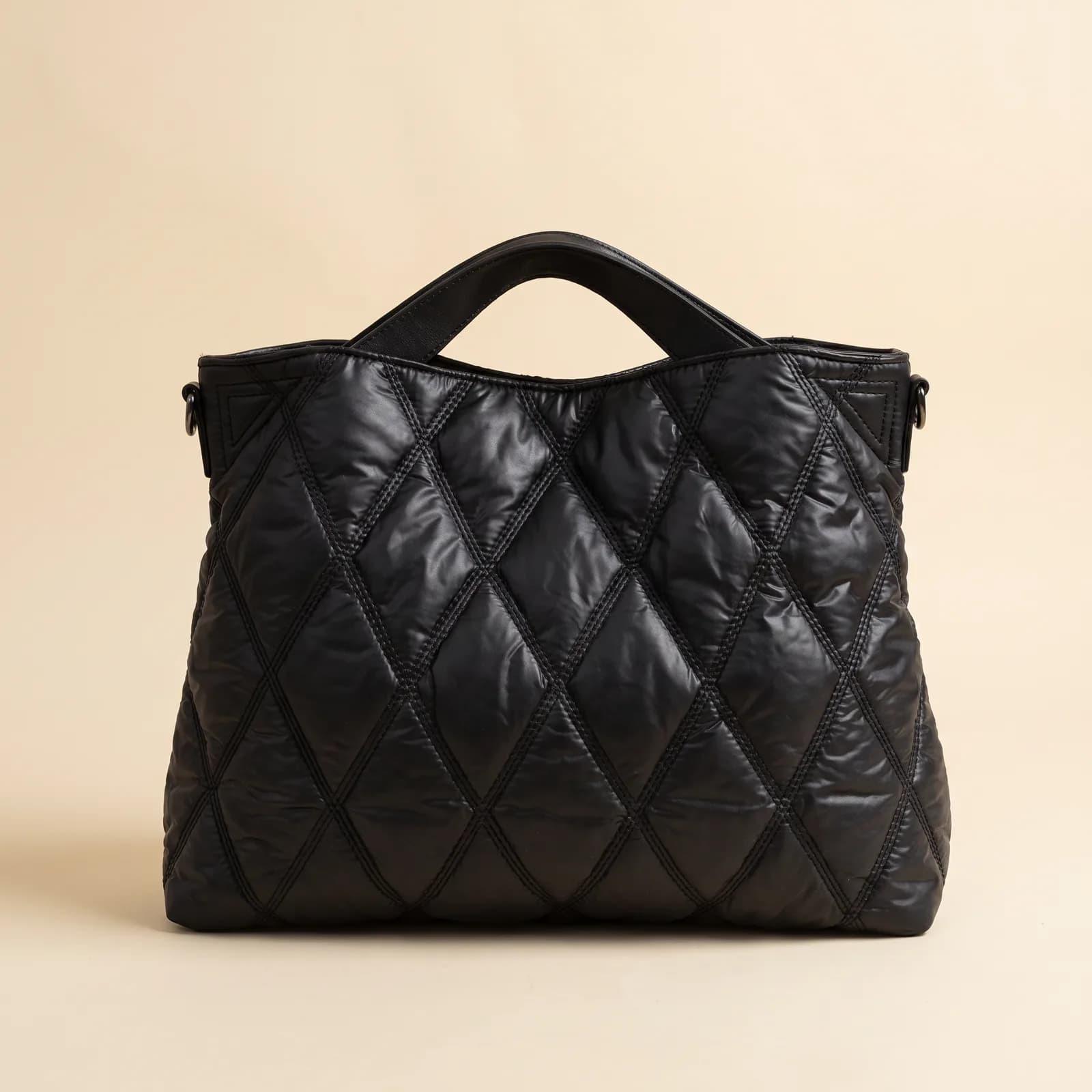 Down Puffer Commuter Tote in Black on a cream studio background