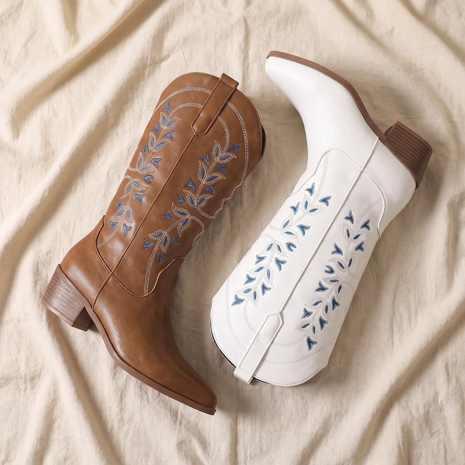 Both boots laid flat top-down on warm cream linen