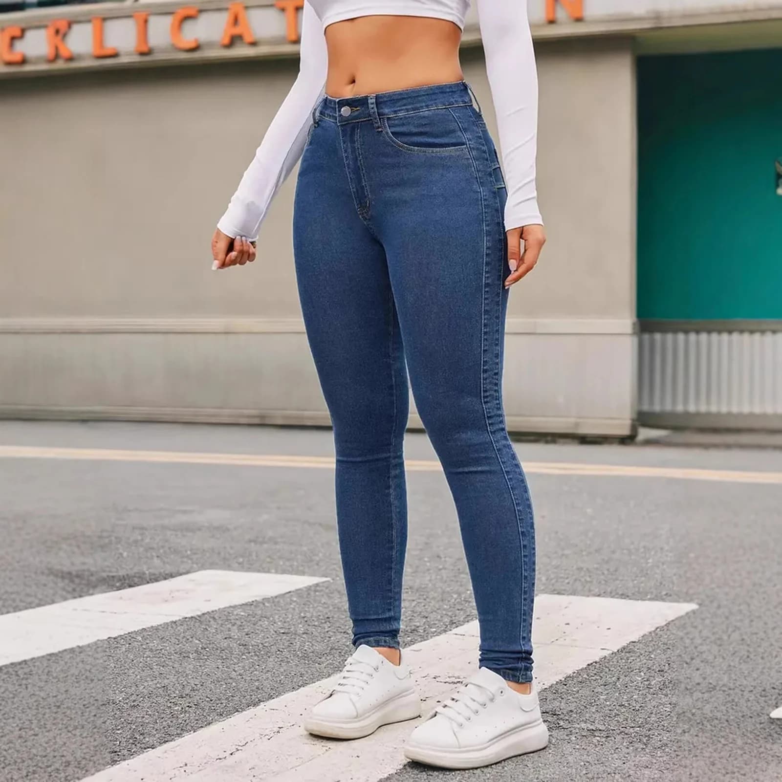 The Medium Wash skinny worn full length on a city street