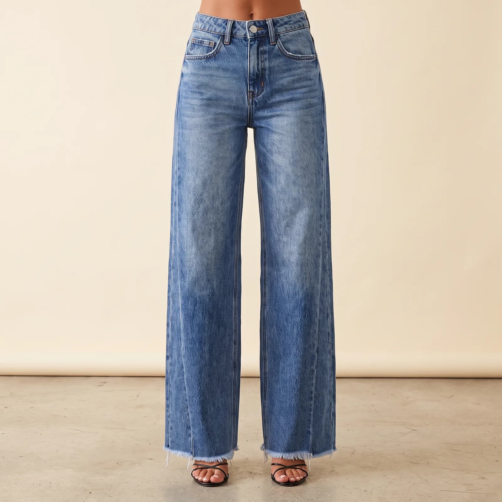 Legs from the waist down wearing the wide-leg jeans, standing in a studio
