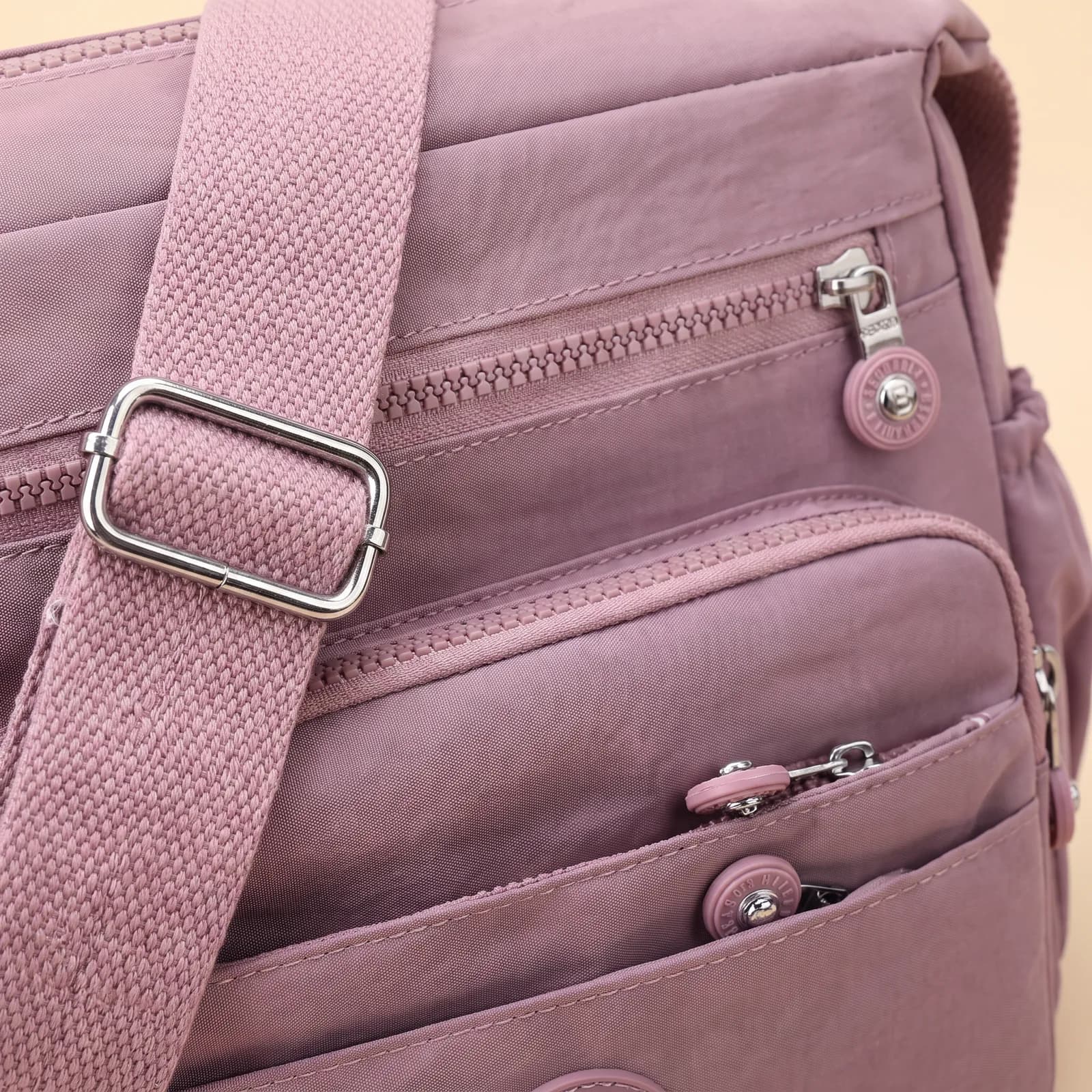 Close-up of the front zip pockets and adjustable strap hardware