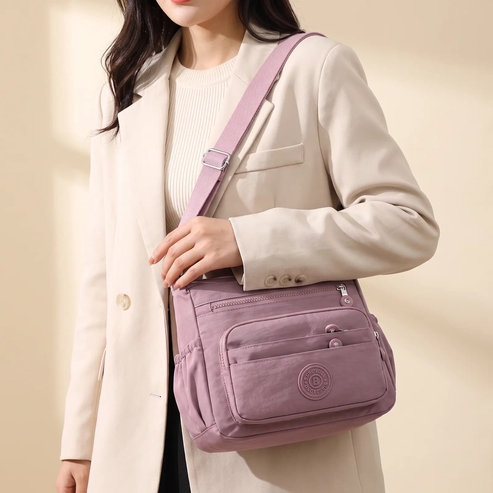 A nylon crossbody bag worn across the body over a jacket, no face
