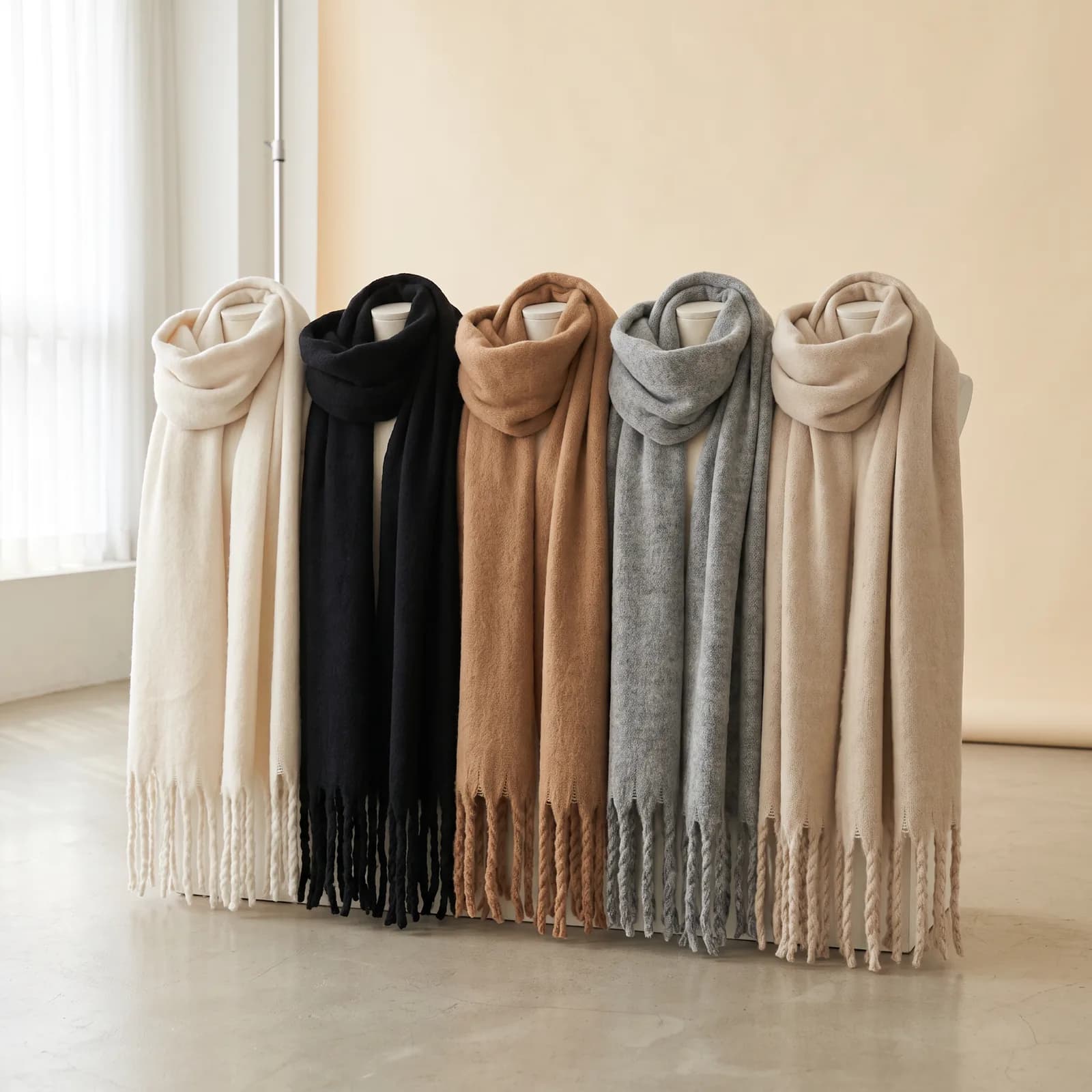 Oat, Black, Camel, Grey, and Sand scarves lined up side by side