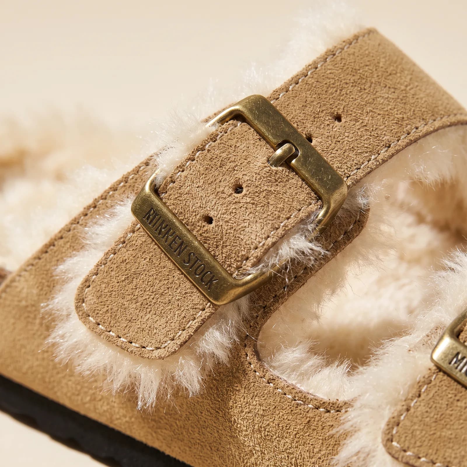Close-up of the metal buckle and faux-shearling lining along the strap edge
