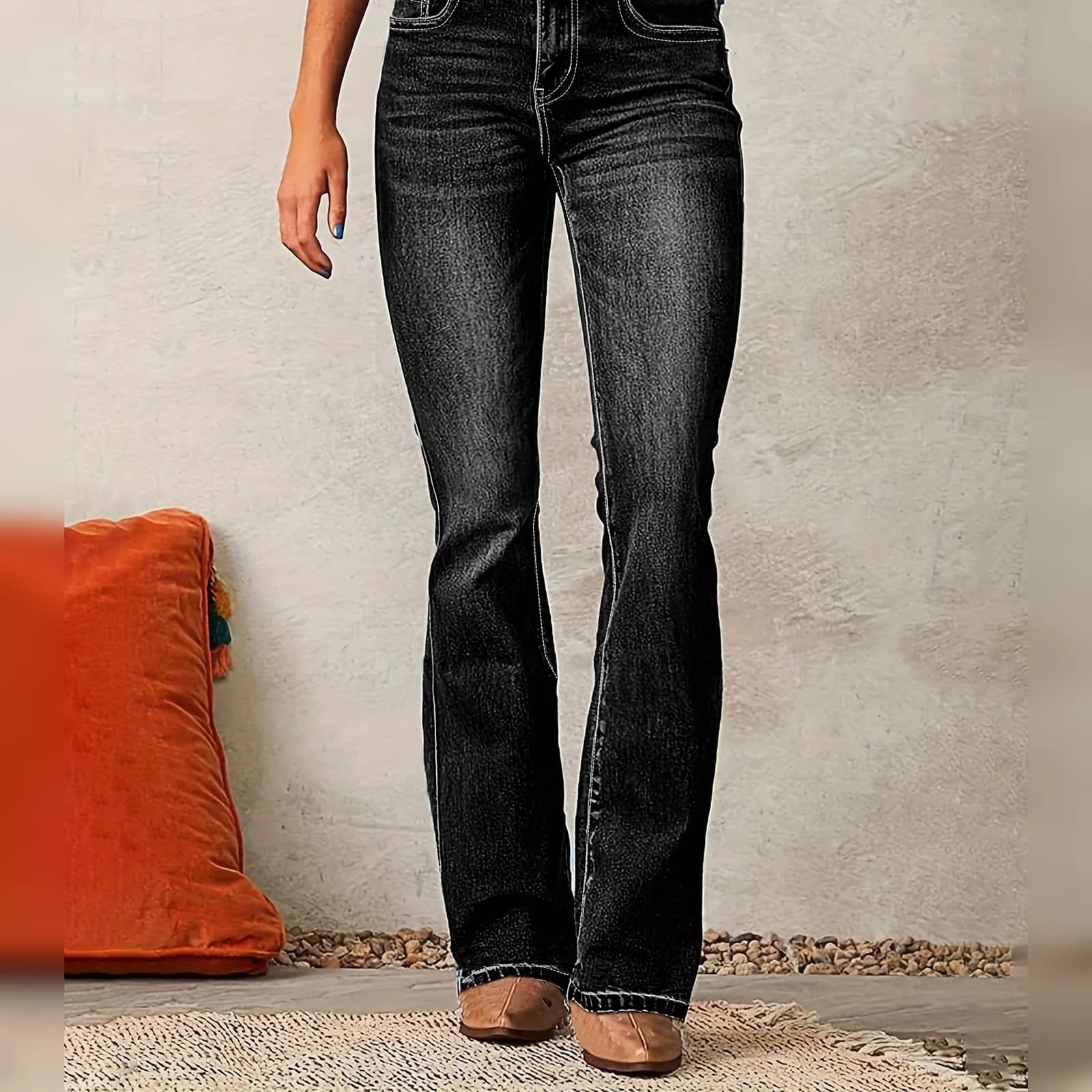The Black bootcut worn standing on a woven rug