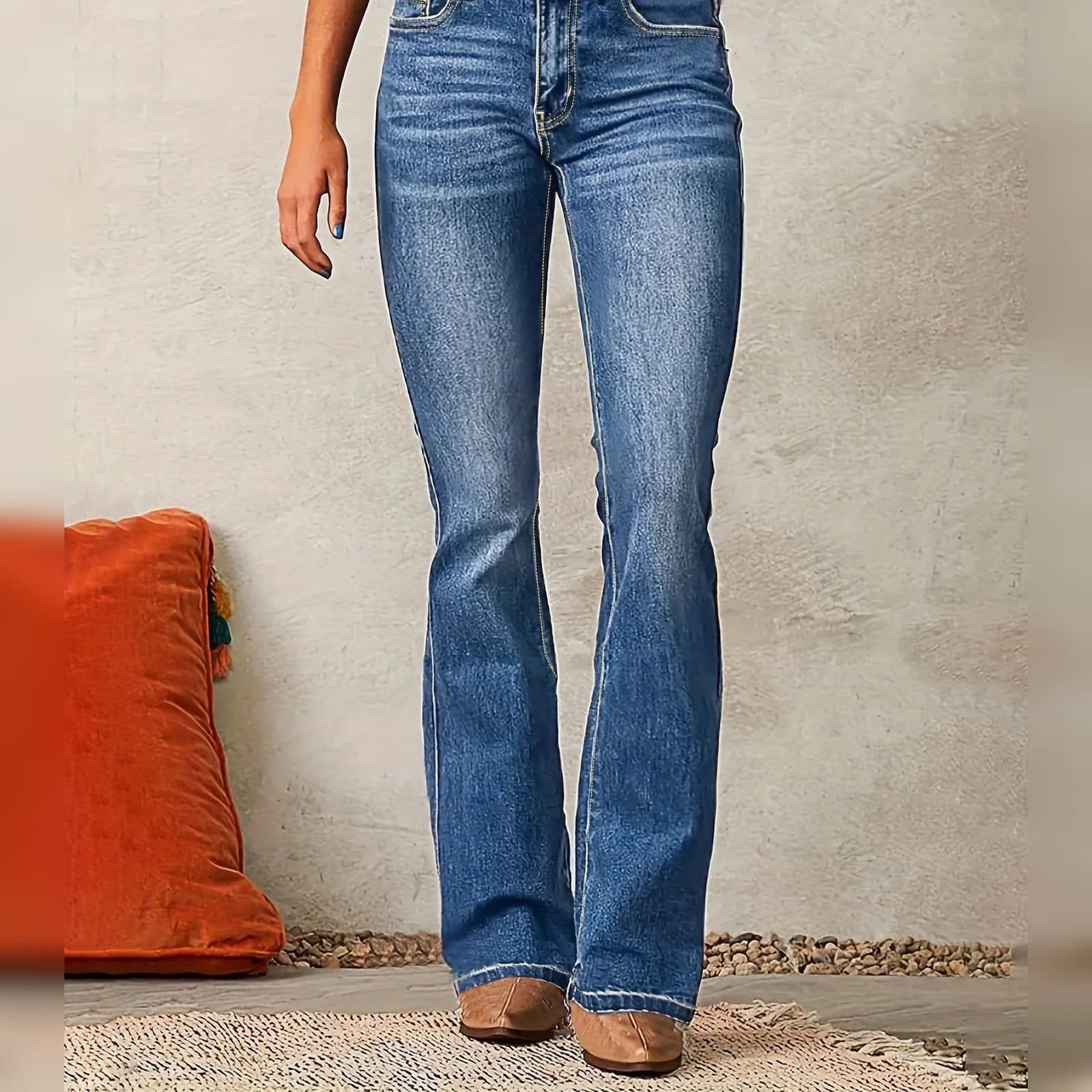 The Light Wash bootcut worn with sneakers, standing