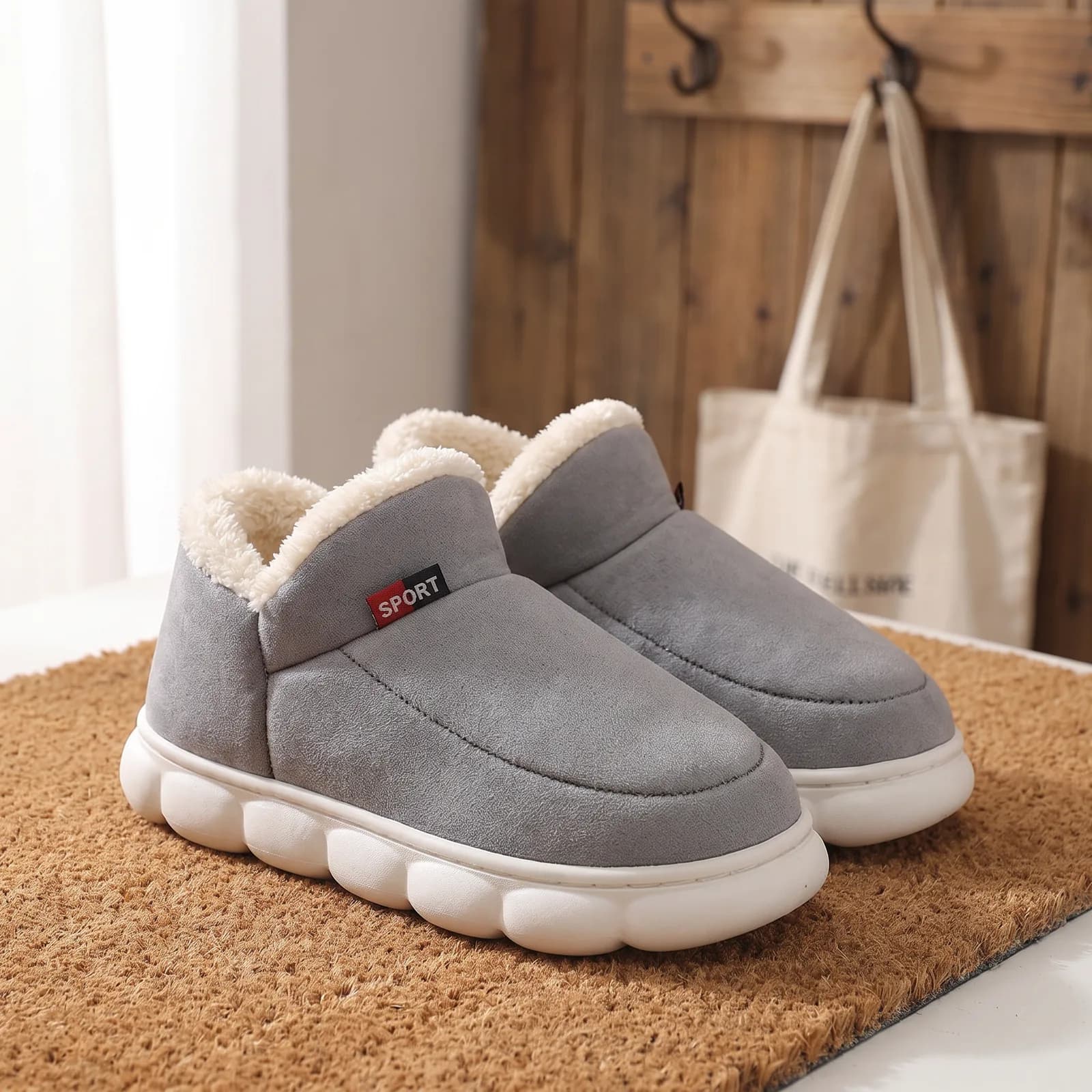 House shoes by a back door next to a coat and a pair of boots, no faces