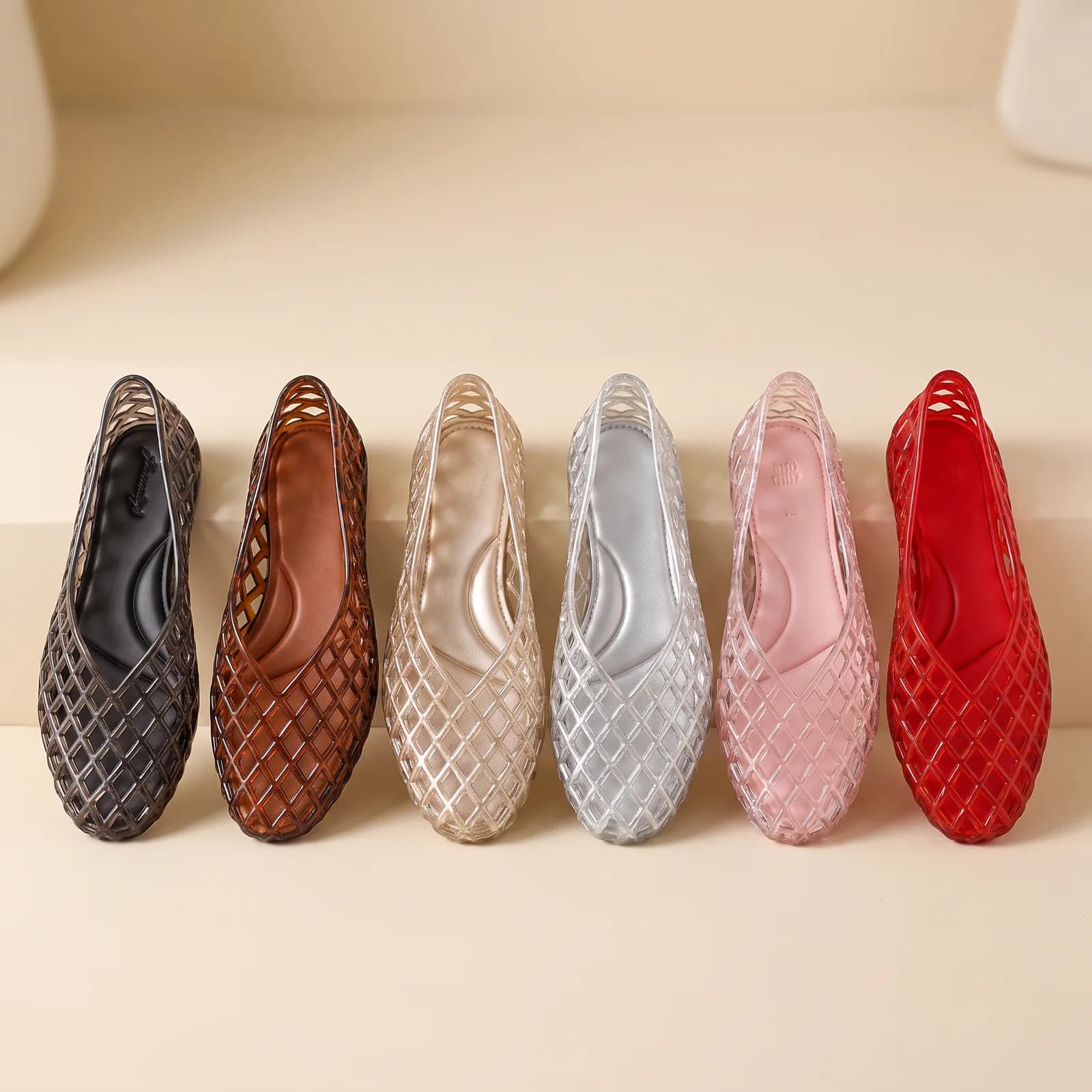 Six jelly flats lined up side by side: Smoke, Tortoise Brown, Champagne, Silver, Blush, Red